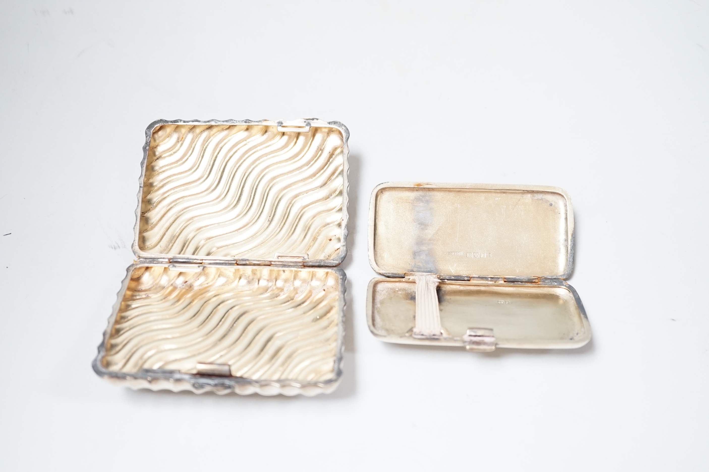 A late Victorian wrythened silver cigarette case, 88mm and a smaller silver cigarette case.